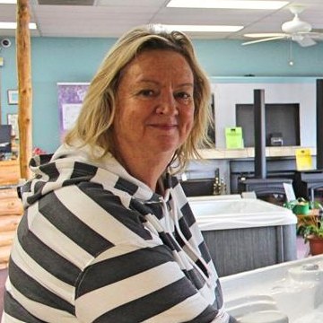Julie Cooper, owner, standing beside a display hot tub in the Mother Lode showroom